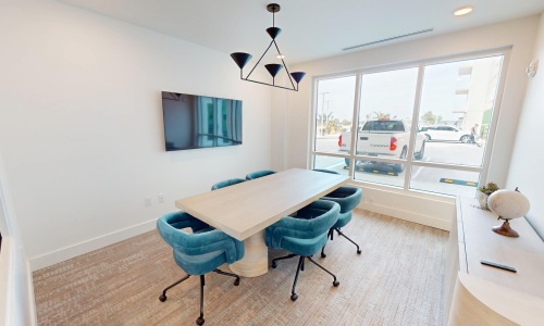 a conference room with table seating and a tv