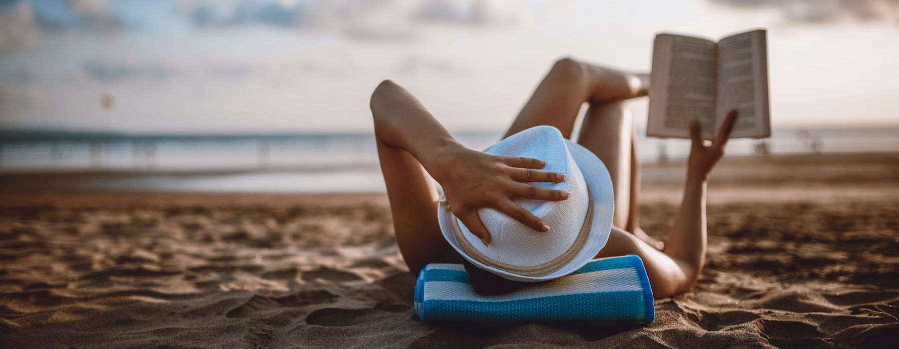 a person reading a book on a beach